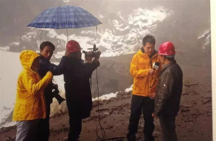 顾国宁在滂沱大雨中播报新闻